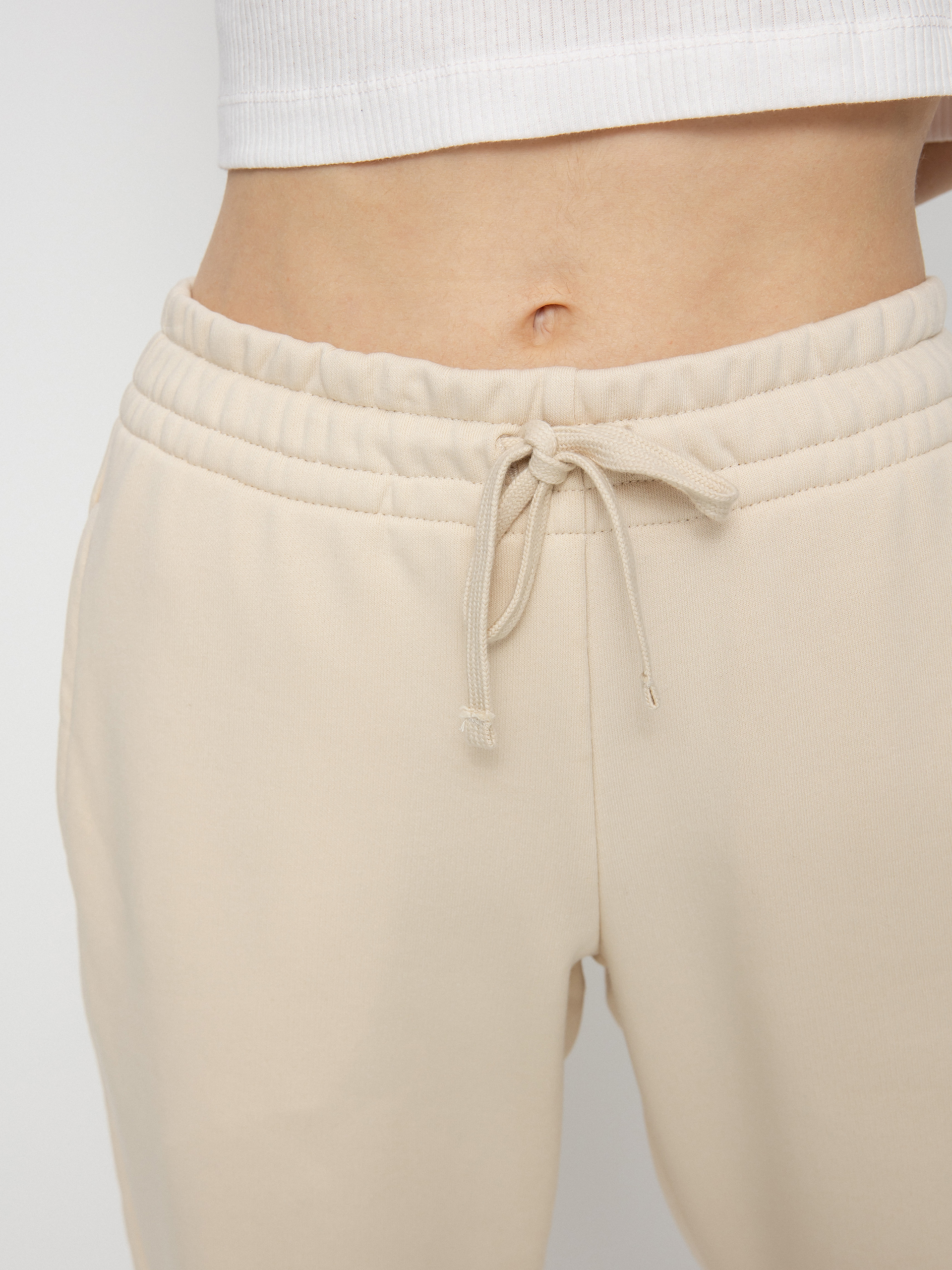 Spodnie New Balance Essentials Celebrate Wmn (beige)